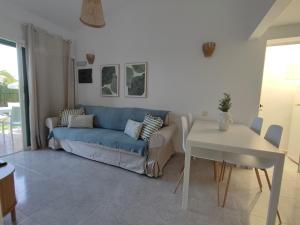 a living room with a blue couch and a table at Bungalow next Yumbo Center in Playa del Ingles