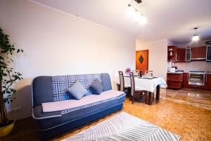 a living room with a blue couch and a table at Apartament u Katarzyny in Grodzisk Mazowiecki +10 photos