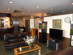 a living room with leather couches and a tv at Terminal Art Inn - Vacation STAY 97356v in Niigata