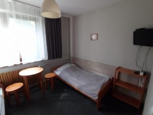 a bedroom with a bed and a table and chairs at Noclegi Pod Dębem in Skawina