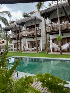 a resort with a swimming pool in front of it at Casa di Maria flats in Icaraí