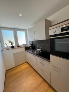 una cocina con fregadero y estufa horno superior en Ferienwohnung Neue Quickbox, en Thale