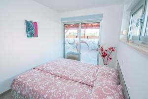 a bedroom with a bed and a vase of flowers at Apartment Maja Medulin in Medulin