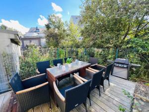 eine Terrasse mit Tisch und Stühlen auf einem Deck in der Unterkunft Charming 5bedroom Home with gym,garden,parking&terrace-HOL15 in Luxemburg (Stadt)