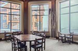 a dining room with a table and chairs and windows at Stonegate Resort Unit A202 in Big White