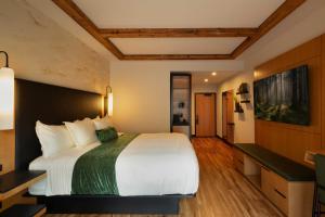 a hotel room with a large bed and a television at The Swiftwater in Swiftwater