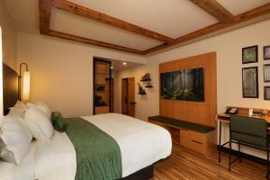 a bedroom with a large white bed and a desk at The Swiftwater in Swiftwater