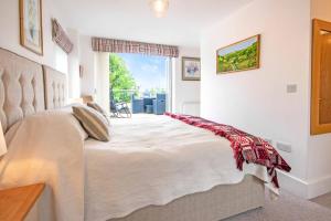 a bedroom with a large bed and a window at Crow's Nest Penthouse Apartment with Free Spa Access in Somerford Keynes +46 photos