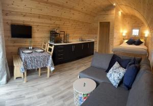 a living room with a couch and a kitchen in a cabin at Milldown Glamping in Coldingham