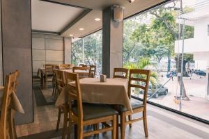 a restaurant with tables and chairs and a large window at Hotel Sebas 202 in Caracas