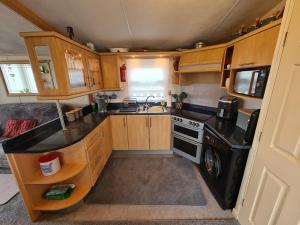 a small kitchen with a sink and a stove at 5 Berth Family Caravan Ingoldmells in Skegness