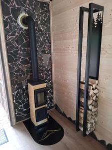 a wood stove in a room with a stone wall at Na kopčoku, zážitkový pobyt in Šula