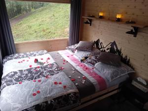 a bed in a bedroom with a window with roses on it at Na kopčoku, zážitkový pobyt in Šula