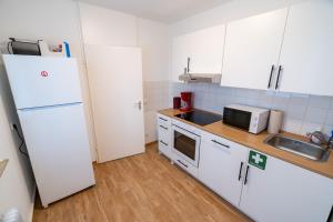a kitchen with white cabinets and a white refrigerator at Monteurwohnung mit Top-Anbindung - Atrium in Pfungstadt