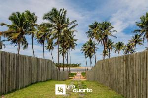 a fence in front of a beach with palm trees at Ponta de Inhambupe Residences in Baixio