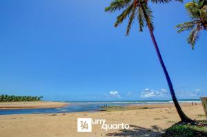 a beach with two palm trees and the ocean at Ponta de Inhambupe Residences in Baixio +37 photos