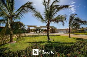 a group of palm trees in front of a building at Ponta de Inhambupe Residences in Baixio