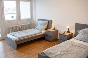 two beds in a room with two lamps on tables at Monteurwohnung mit Top-Anbindung - Atrium in Pfungstadt