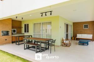 a patio with a table and chairs and a couch at Ponta de Inhambupe Residences in Baixio