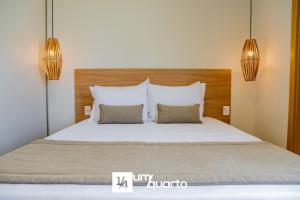a bedroom with a large bed with two pillows at Ponta de Inhambupe Residences in Baixio