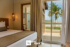 a bedroom with a bed and a view of the beach at Ponta de Inhambupe Residences in Baixio
