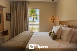 a bedroom with a large bed with a large window at Ponta de Inhambupe Residences in Esplanada