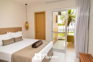 a bedroom with a bed and a balcony at Ponta de Inhambupe Residences in Esplanada +81 photos