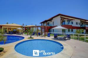 a resort with a swimming pool in front of a building at Ponta de Inhambupe Residences in Baixio