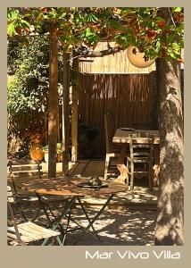 un patio avec une table et des chaises sous un arbre dans l'établissement MarVivo Villa - Rez de Jardin - Plage 3' à pied, à La Seyne-sur-Mer