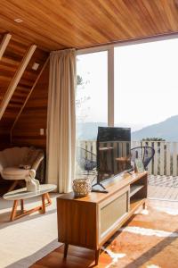 a living room with a television on a table at Cabana Snowflake Urubici in Urubici