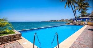 a swimming pool with the ocean in the background at Oceanfront-Ocean View in Bucerias Casita Oasis Condo - Large Studio in Bucerías