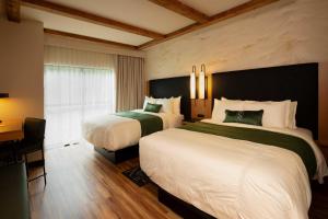 a hotel room with two beds and a desk at The Swiftwater in Swiftwater