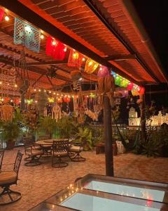 a patio with a table and chairs and lights at Grann Posada Xilitla in Xilitla