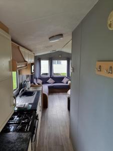 eine Küche und ein Wohnzimmer eines Wohnwagens in der Unterkunft Newquay Bay Holiday Resort Caravan 142 in Newquay Bay Resort