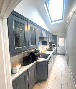 a large kitchen with blue cabinets and a skylight at 55 Malin Road in Moville +8 photos