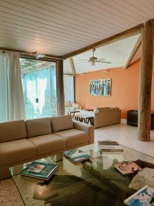 a living room with a couch and a glass table at Casa Ponta de Areia in Corumbau