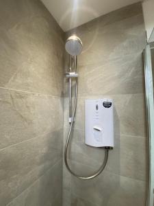 a shower with a shower head in a bathroom at 6 Smithhills - Sleeps 3 Central Excellent Transport Links Glasgow & Airport in Paisley +15 photos