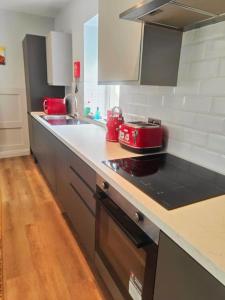 a kitchen with a counter top with a red appliance at Chelsea 2 bedroom promenade apartment in Blackpool +13 photos