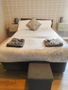 a bed with a pair of shoes on top of it at Chelsea 2 bedroom promenade apartment in Blackpool