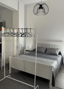 a white bedroom with a bed with a metal frame at Villa Marta loft diáfano con jardín y aparcamiento en Villa histórica in Renedo de Piélagos