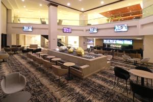 a lobby with a waiting area with tables and chairs at MS Milenium Monterrey Curio Collection by Hilton in Monterrey
