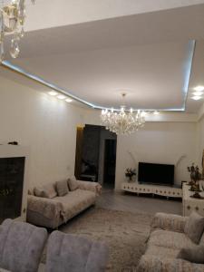 una sala de estar con 2 sofás y una lámpara de araña. en Holiday home, en Baku