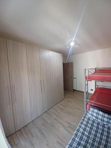 a room with a red bed and wooden cabinets at Casa di Sara in Pescasseroli
