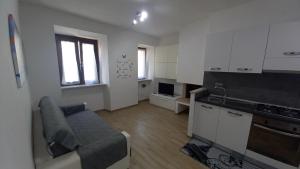 a living room with a couch and a kitchen at Casa di Sara in Pescasseroli