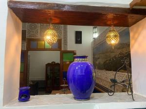 a large blue vase sitting on a table with lights at Dar ZaZ in Fez