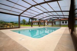 an indoor pool with a retractable roof at Piscina climatizada y cubierta 365 dias en Casa Rural con Encanto El Puentuco una de las casas mas valoradas de Cantabria in Villacarriedo