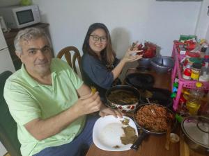 a man and a woman sitting at a table with food at Historia Hostel in Skopje