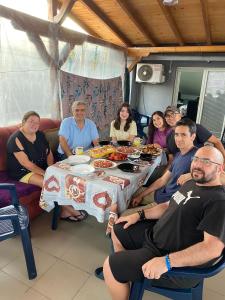 a group of people sitting around a table with food at Historia Hostel in Skopje
