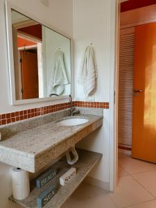 a bathroom with a sink and a mirror at Casa Ponta de Areia in Corumbau