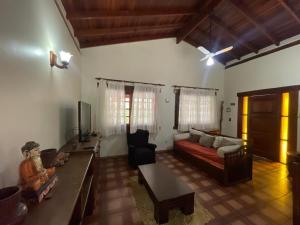 a living room with a couch and a table at FANTÁSTICA CASA COM ÁREA DE PISCINA até 10 PESSOAS em MARESIAS SÃO SEBASTIÃO in Maresias